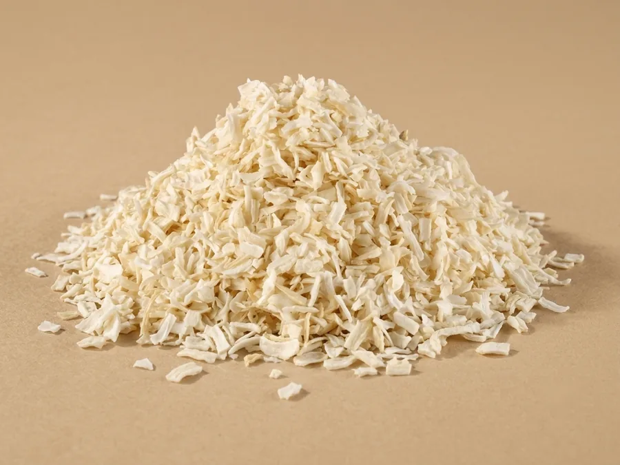 Dehydrated white onion, chopped grade, 3 to 5 mm cream-ivory chips in a loose pile on kraft paper.