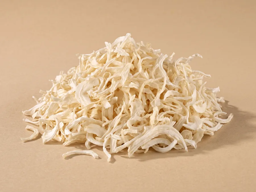 Dehydrated white onion flakes, 8 to 20 mm, pale ivory curved strips shown in a loose pile on kraft paper.