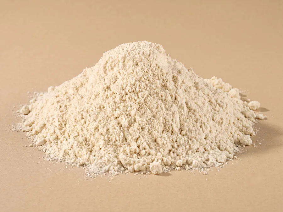 Dehydrated white onion powder, 100 mesh, a soft pale ivory mound on kraft paper.