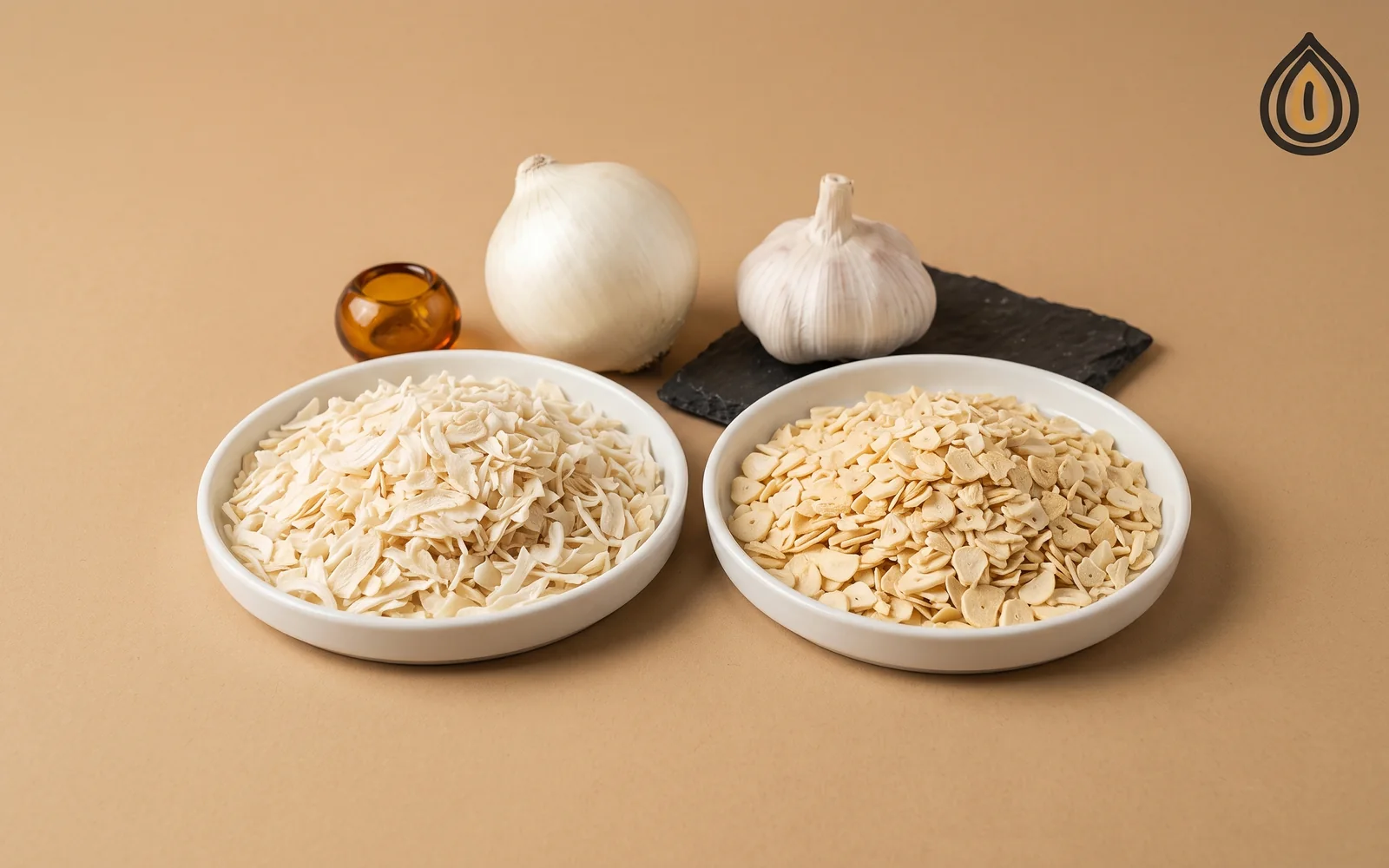 Two dishes on kraft paper, ivory dehydrated onion flakes and pale yellow dehydrated garlic flakes, with a whole bulb of each