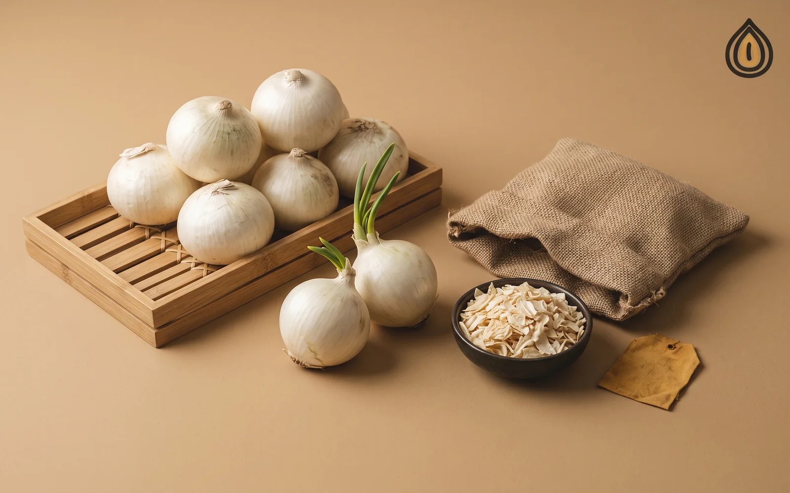 Bamboo tray of stored white onions with sprouted rejects set apart and a bowl of onion flakes on a plain backdrop