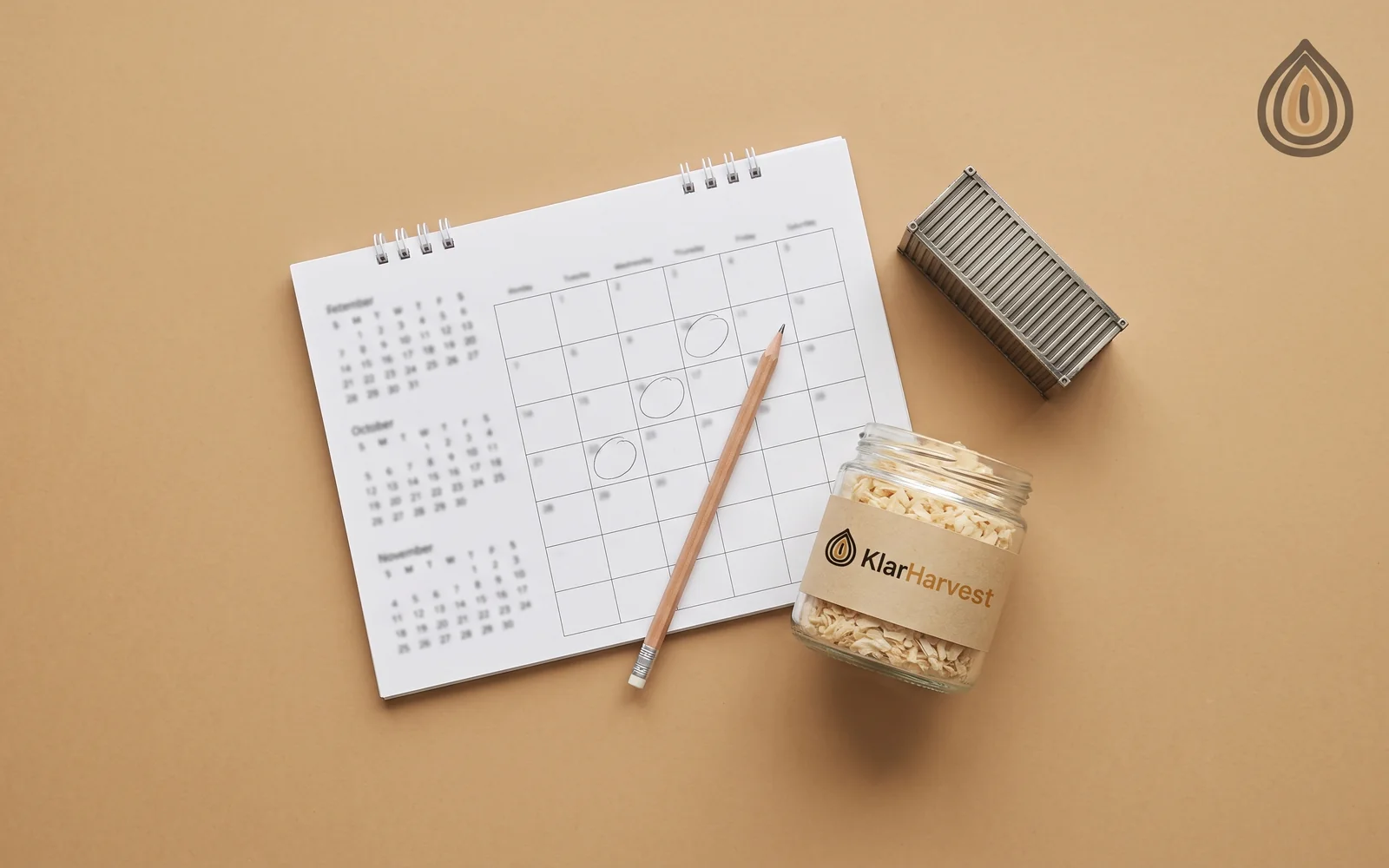 Desk calendar with three months visible beside a sample jar of onion flakes and a container-shaped paperweight