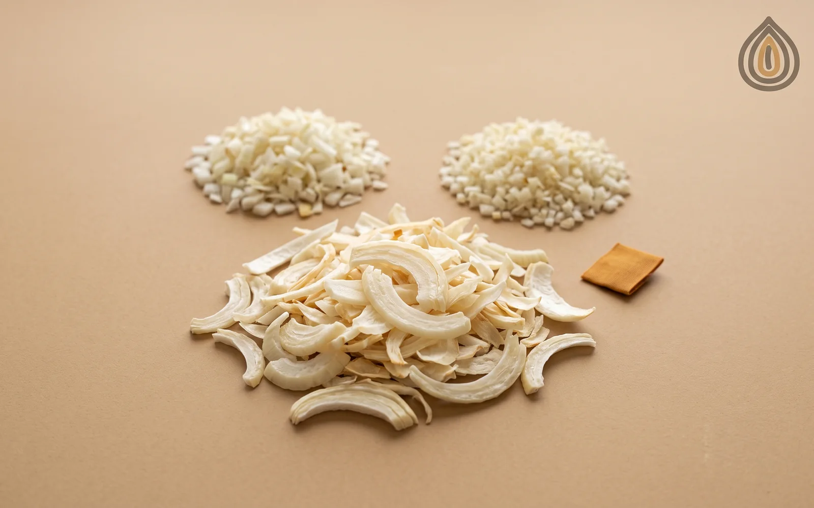 Heap of large ivory kibbled onion pieces on kraft paper beside smaller chopped and minced pieces for comparison